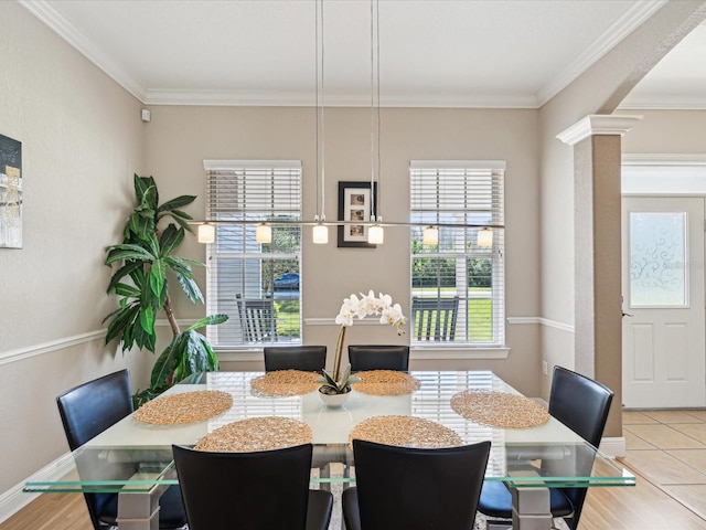 tiled dining area featuring decorative columns, arched walkways, baseboards, and crown molding