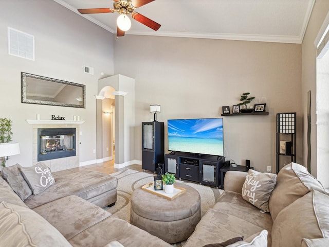 living room with visible vents, a fireplace, and crown molding