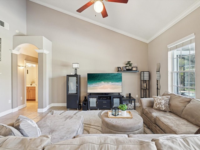 living room with ceiling fan, baseboards, decorative columns, ornamental molding, and light tile patterned flooring