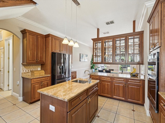 kitchen featuring a sink, stainless steel appliances, arched walkways, and light tile patterned flooring