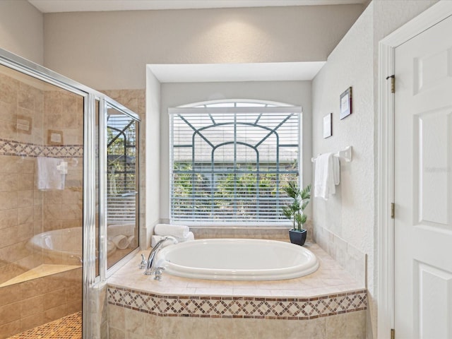 full bath featuring a garden tub, a stall shower, and a textured wall