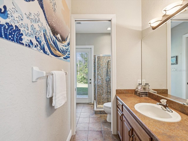 bathroom featuring vanity, a shower stall, tile patterned floors, toilet, and a textured wall