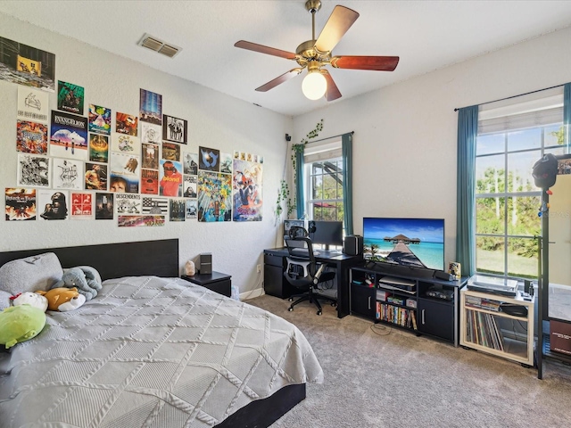 bedroom with carpet, visible vents, and ceiling fan