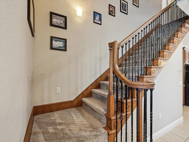 staircase with tile patterned floors and baseboards