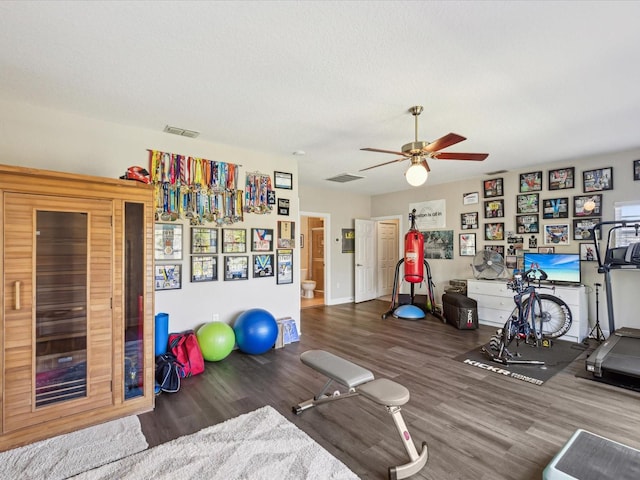 workout area featuring wood finished floors, visible vents, and ceiling fan