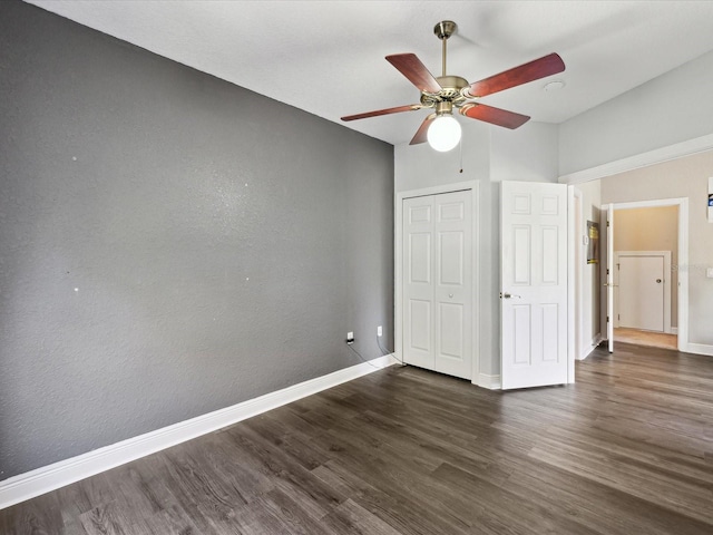 unfurnished bedroom featuring a closet, a ceiling fan, baseboards, and wood finished floors