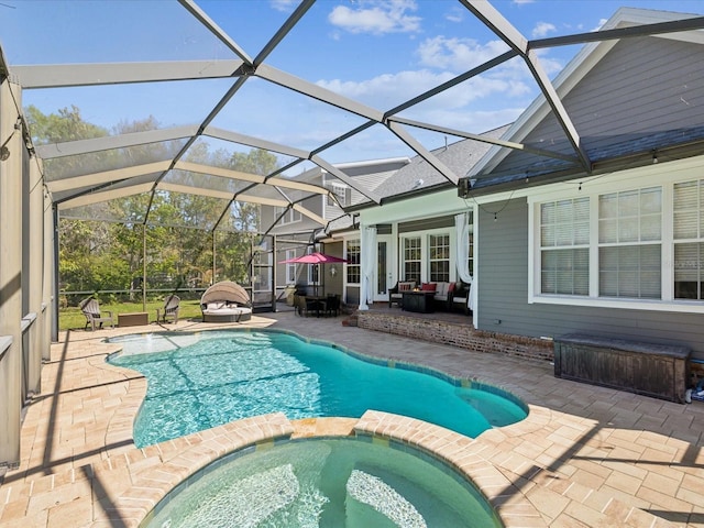 view of swimming pool with glass enclosure, a patio, and a pool with connected hot tub