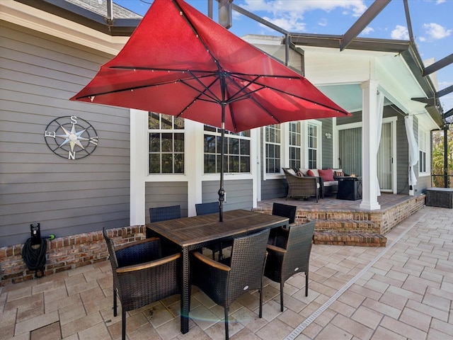 view of patio featuring glass enclosure, an outdoor living space, and outdoor dining space