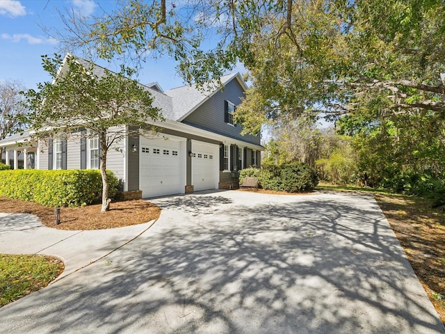 view of home's exterior featuring a garage, roof with shingles, and driveway