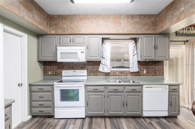 kitchen with gray cabinets, white appliances, and a sink