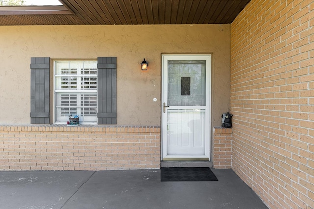 entrance to property with stucco siding and brick siding