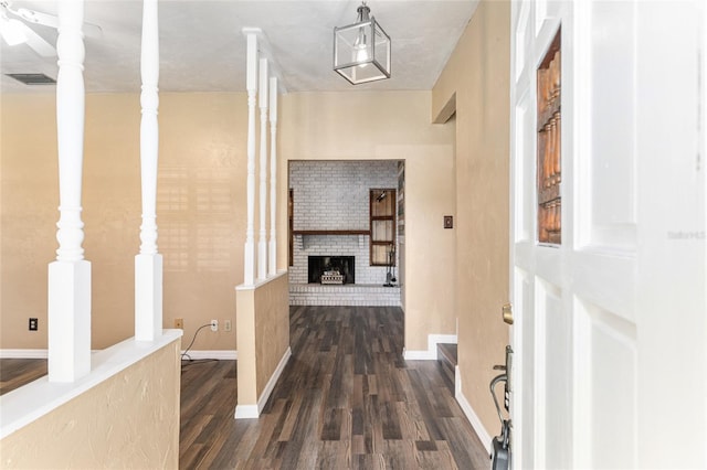 corridor featuring visible vents, baseboards, and dark wood-style floors