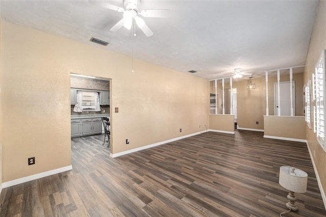 unfurnished room featuring dark wood-style floors, visible vents, baseboards, and a ceiling fan