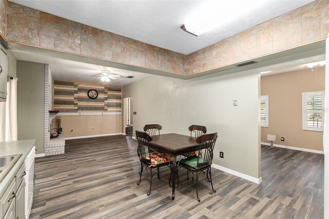 dining space with visible vents, ceiling fan, baseboards, and wood finished floors