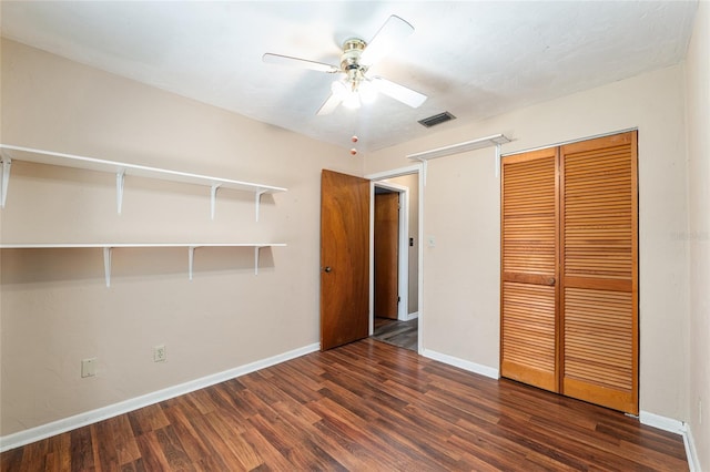 unfurnished bedroom featuring wood finished floors, visible vents, a closet, and baseboards