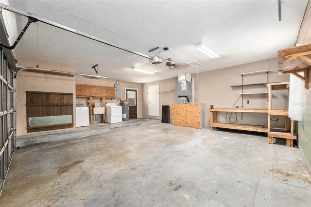 garage with water heater, electric panel, heating unit, independent washer and dryer, and a sink