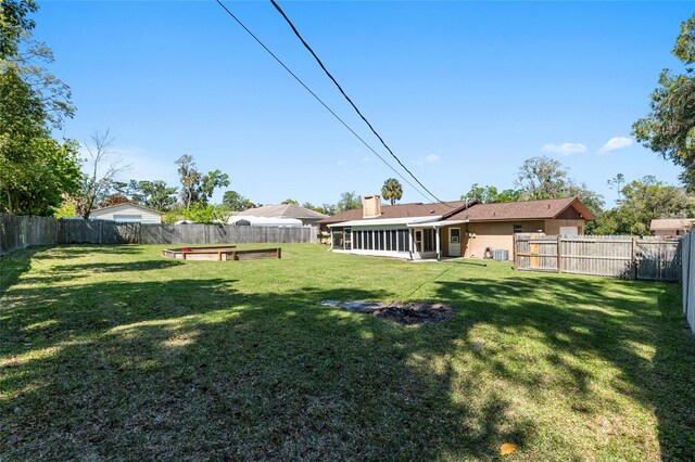 view of yard with a fenced backyard and a sunroom