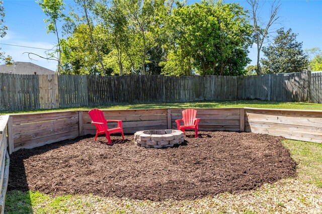 view of yard with a fenced backyard and a fire pit