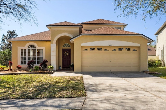 mediterranean / spanish-style house featuring stucco siding, concrete driveway, a garage, and roof with shingles