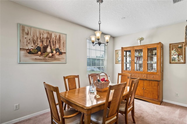 dining space featuring a chandelier, baseboards, a textured ceiling, and carpet