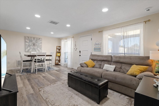 living room featuring recessed lighting, wood finished floors, visible vents, and baseboards