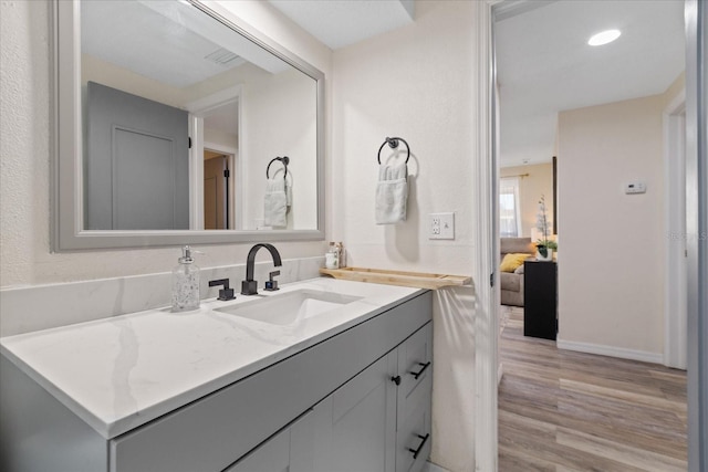 bathroom with vanity, baseboards, and wood finished floors