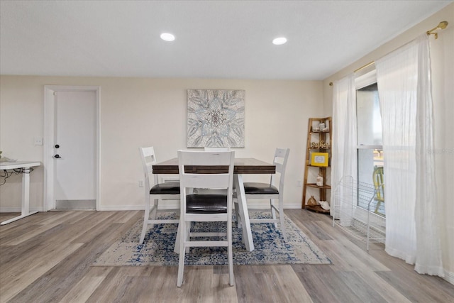 dining space with recessed lighting, baseboards, and wood finished floors