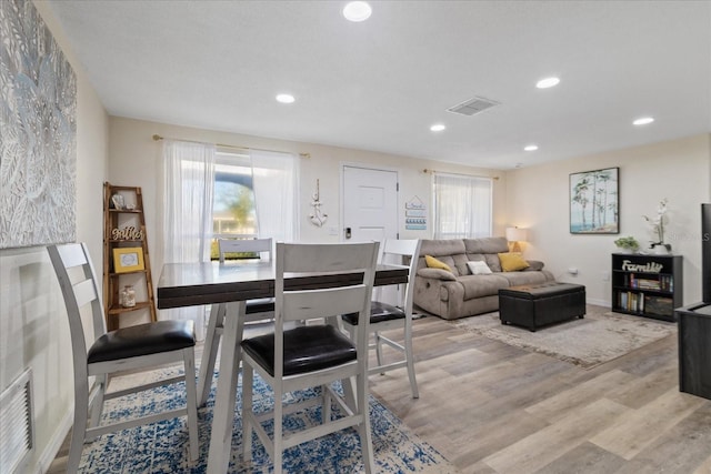 dining room with a healthy amount of sunlight, visible vents, and light wood finished floors