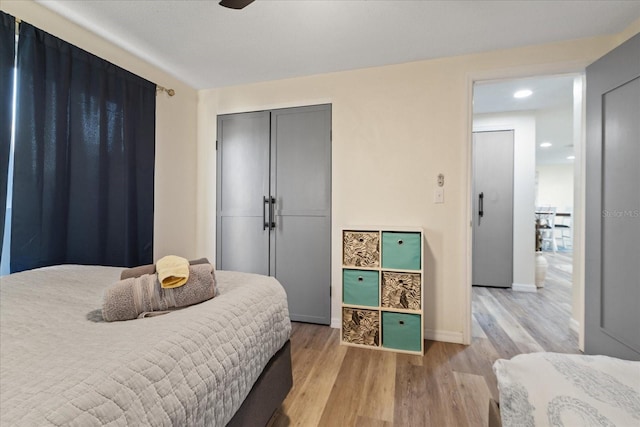 bedroom with baseboards, a closet, and light wood finished floors