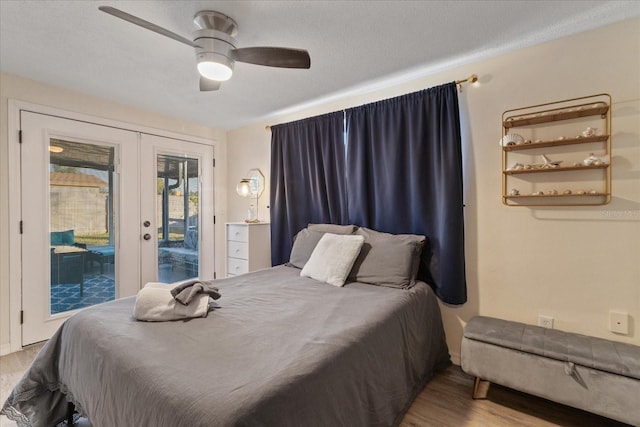 bedroom with access to exterior, a textured ceiling, wood finished floors, french doors, and ceiling fan