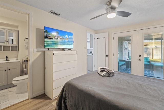 bedroom with visible vents, french doors, ensuite bath, and access to outside