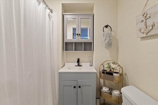 bathroom featuring curtained shower, toilet, and vanity