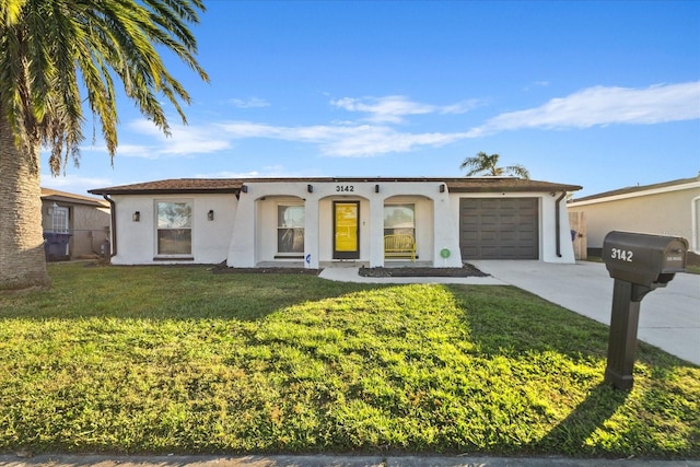 view of front of house with a front lawn, a garage, driveway, and stucco siding