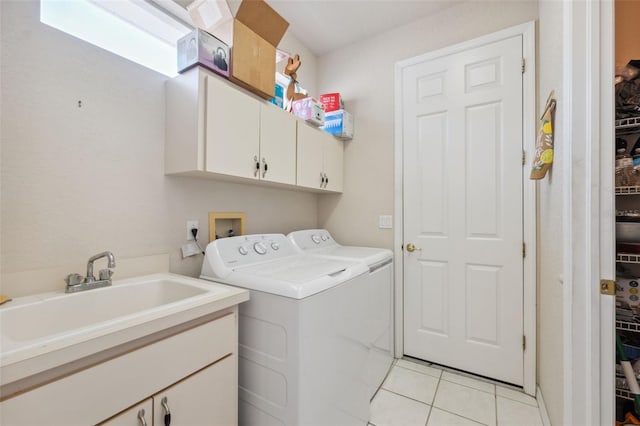 laundry area featuring light tile patterned floors, cabinet space, independent washer and dryer, and a sink