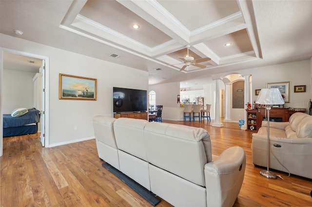living area with light wood-style flooring, coffered ceiling, ornate columns, and ornamental molding