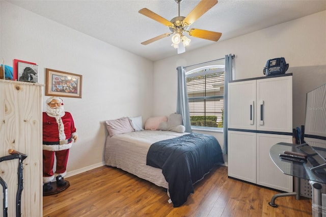 bedroom featuring ceiling fan, baseboards, and hardwood / wood-style floors
