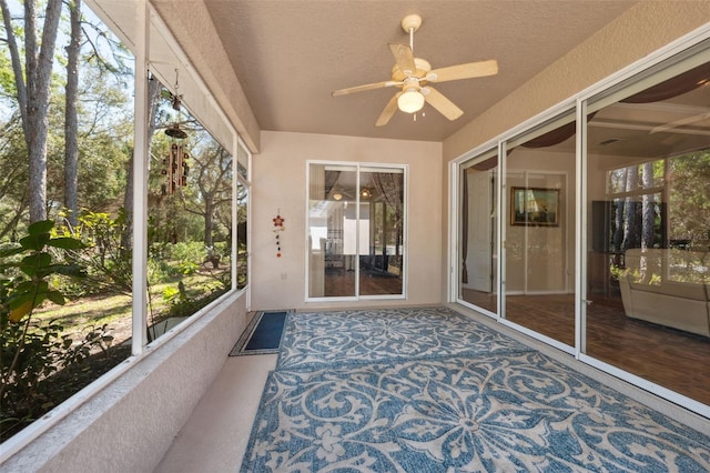 unfurnished sunroom with a ceiling fan