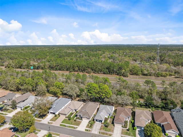 drone / aerial view featuring a residential view and a view of trees