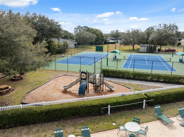 view of tennis court with playground community and fence