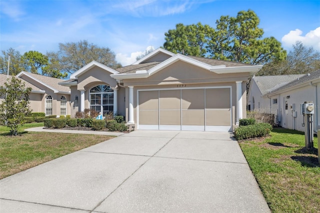 single story home featuring a front lawn, an attached garage, and stucco siding