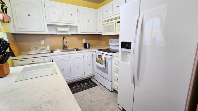 kitchen featuring white cabinetry, white appliances, light countertops, and a sink