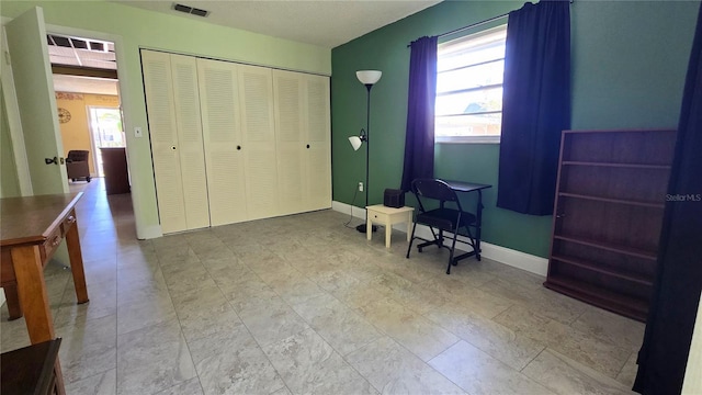 bedroom with a closet, visible vents, multiple windows, and baseboards