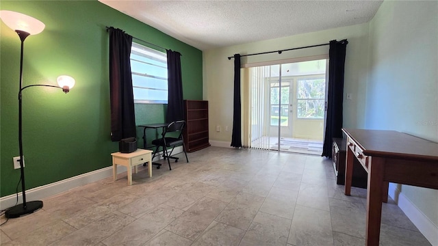 living area with baseboards and a textured ceiling