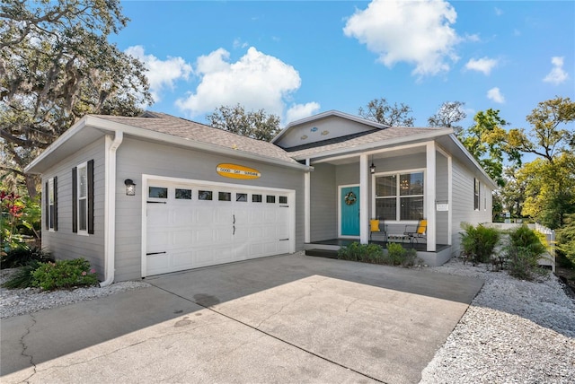 single story home featuring a garage, covered porch, concrete driveway, and a shingled roof