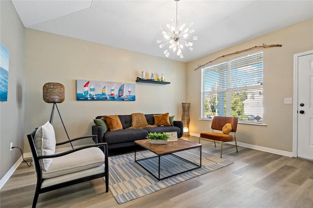 living area featuring baseboards, an inviting chandelier, and wood finished floors