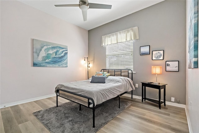 bedroom with light wood-type flooring, baseboards, and ceiling fan