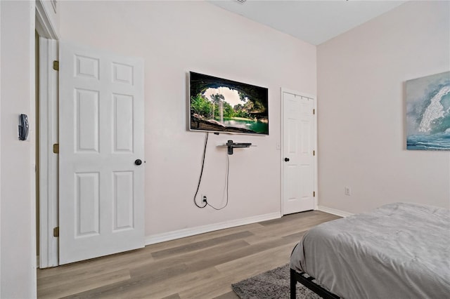 bedroom with baseboards and wood finished floors