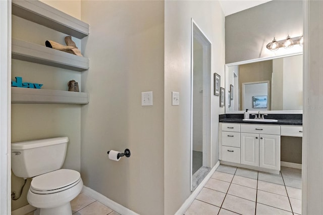 bathroom featuring tile patterned floors, baseboards, toilet, and vanity