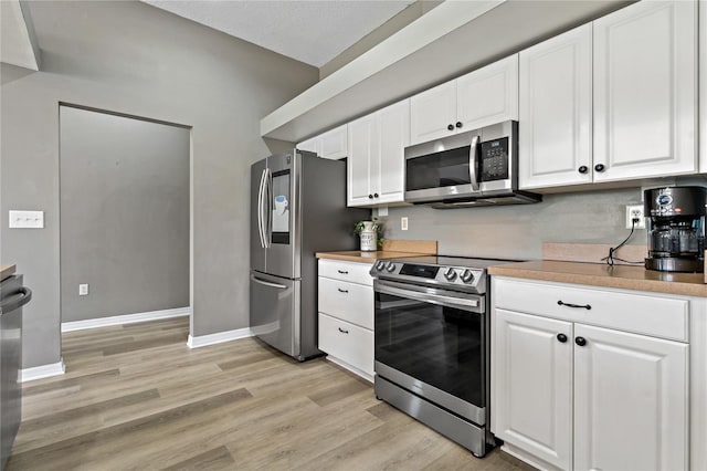 kitchen featuring stainless steel appliances, white cabinets, and light wood finished floors