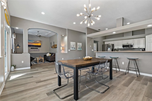 dining room featuring ceiling fan with notable chandelier, light wood-style flooring, recessed lighting, and baseboards